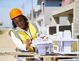 Lady Engineer inspecting a model building at a construction site